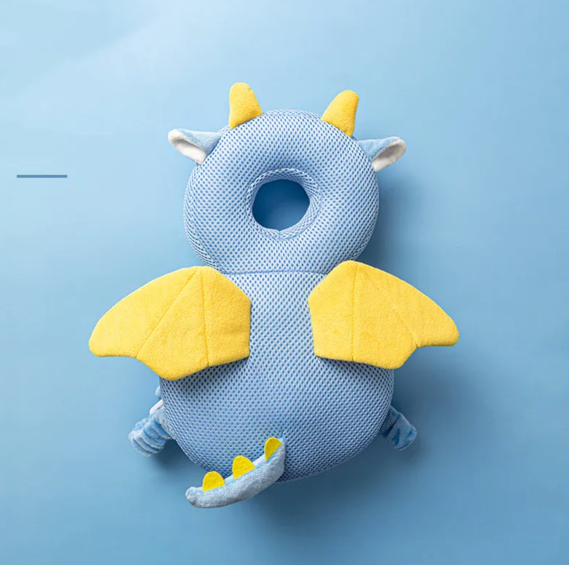 Blue dragon-shaped pillow with yellow accents on a light blue background